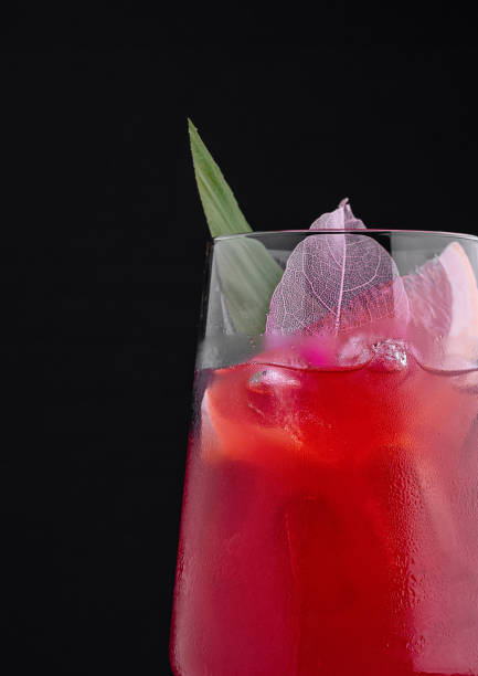 istock Red cocktail with ice cubes, grapefruit and leaf decoration on black background 2177384179