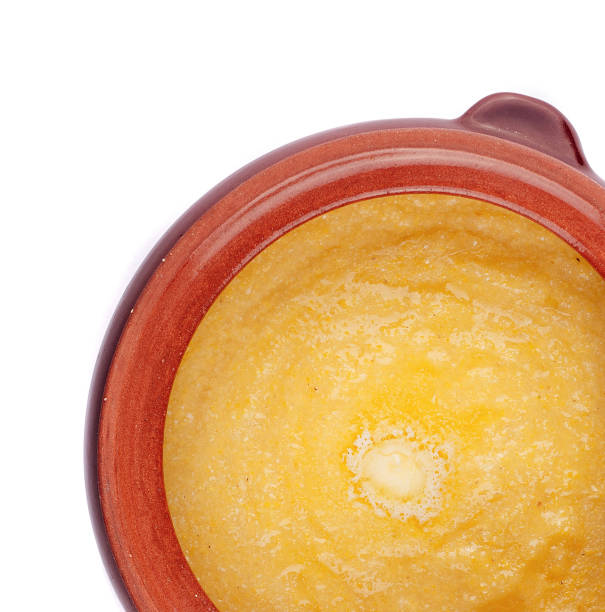 istock Steaming polenta with melting butter in clay pot on white background 2177384180