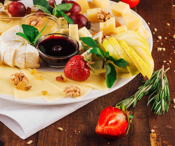 istock Delicious cheese platter with organic ingredients arranged on wooden table 2177385981