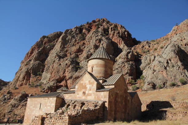 istock Stone church with a dome set against rocky mountains under a clear blue sky. 2177387409