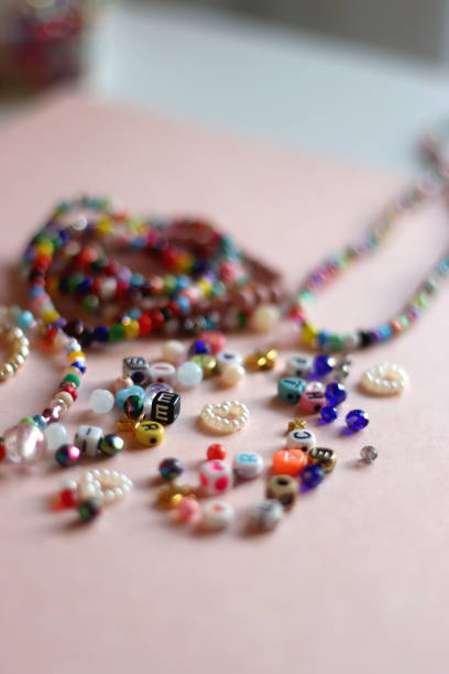 istock Colorful Bracelets, Necklaces And Beads On Pink Background 2177389585