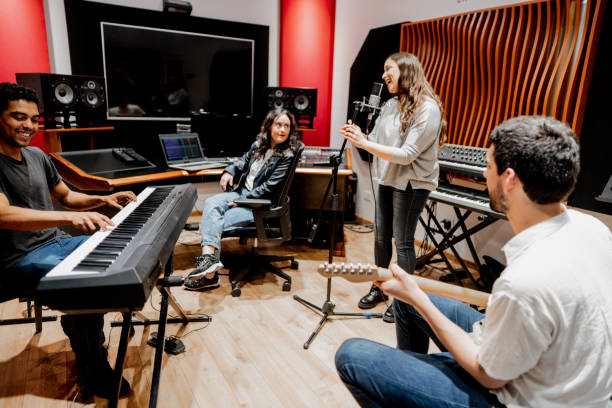 Musicians singing and playing at music studio