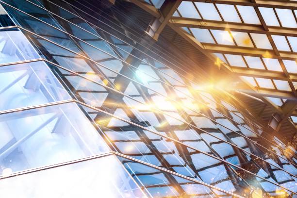 istock A low-angle view of a modern building's glass facade, with bright sunlight shining through the glass panels. 2177391519