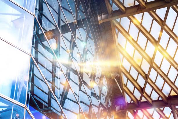 istock Sunlight streams through the steel framework of a modern building, casting geometric shadows on the glass facade. 2177391626