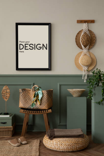 istock Spring composition of warm living room interior with mock up poster frame, wooden stool, braided bag, hat, stylish macrame, green stands, slippers and personal accessories. Home decor. Template. 2177392416