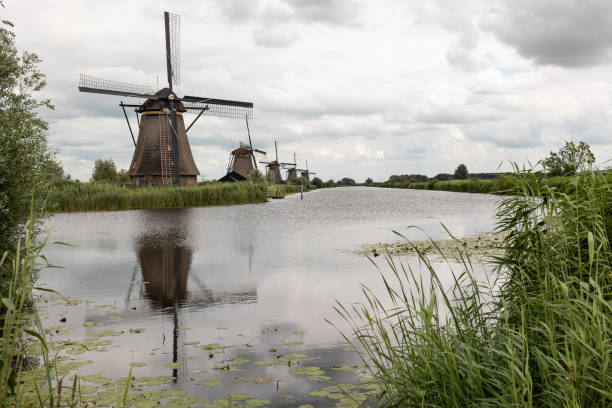 istock Group of historic windmills at the river, reflection in the water. 2177392583
