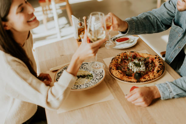 istock Couple enjoying a romantic dinner together in a cozy restaurant, celebrating with a toast over delicious cuisine on a warm evening 2177393021