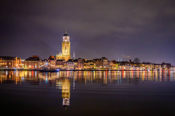 Nighttime view on the city of Deventer located at the banks of the river IJssel in Overijssel, The Netherlands in the dark december days before Christmas. The tower of the St. Lebuinus Church or great Church is a landmark in the city center.