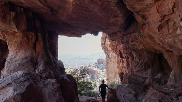 istock Male hiker in sandstone cave looking out 2177395663