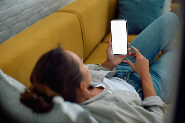 istock Close up of woman using smart phone while relaxing on the sofa. 2177400365