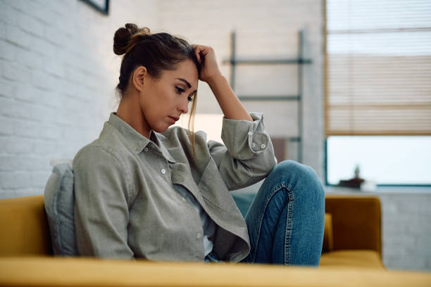 istock Young thoughtful woman sitting alone on the sofa. 2177400520