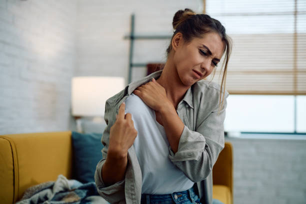 istock Young woman feeling pain in her shoulder while sitting at home. 2177400664