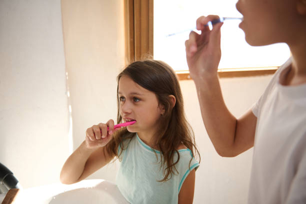 istock Children brushing teeth together in bright bathroom setting 2177400782