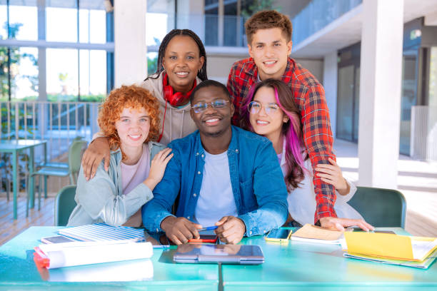 istock Happy diverse group of students studying in the library looking at camera 2177400805