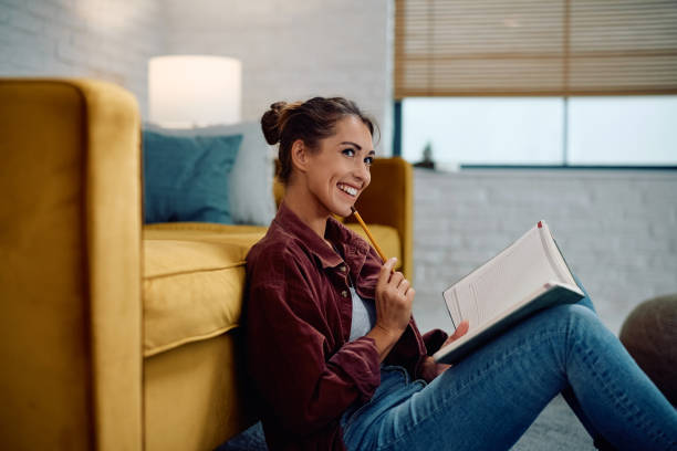 istock Happy woman contemplating while writing in notebook at home. 2177400989