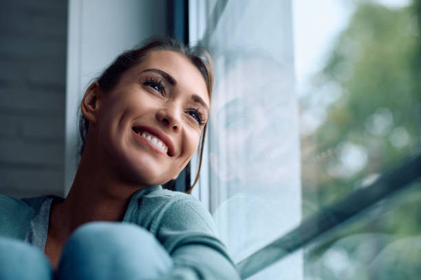 istock Happy woman day dreaming while relaxing by the window. 2177401140