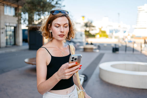 istock Young woman using e-banking on a smartphone in the city 2177407693
