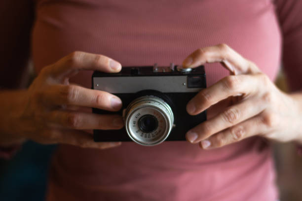 Close up of woman's hands with retro photo camera