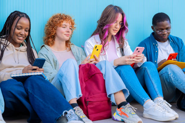 istock A group of diverse young people sitting outdoors using smartphones and notebooks 2177410579
