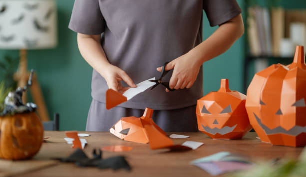 istock Woman is making Halloween paper pumpkins. 2177410910
