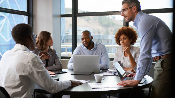 istock Multi-Cultural Business Team Meeting Collaborating Sitting Around Table In Modern Office Together 2177413429