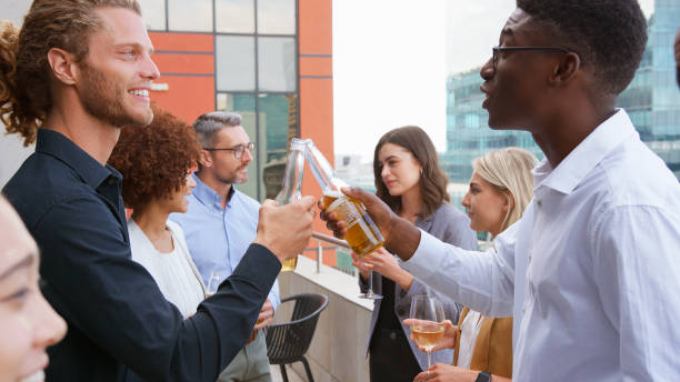istock Multi-Cultural Business Team Celebrating Outdoors For After Work Drinks On Office Rooftop Or Bar 2177414965