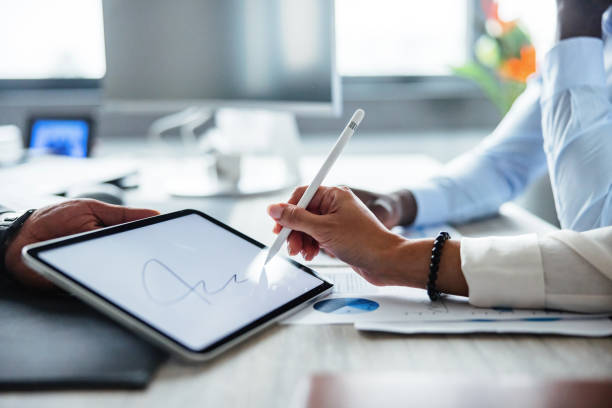 Business Professionals Signing Digital Document