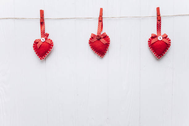 Two Sunlit Magenta Hearts Hanging on a Line