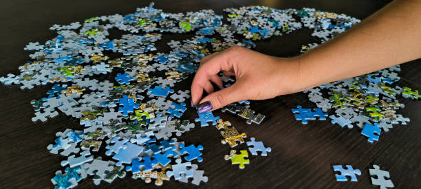 istock Girl assembling a mosaic. Assembling puzzles. A hobby for the soul. Development of fine motor skills of hands. Fun games for the whole family. 2177421174