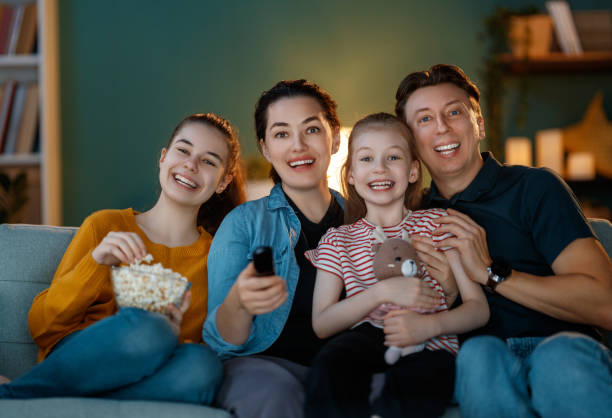 Family enjoying a movie at the cinema with focused expressions
