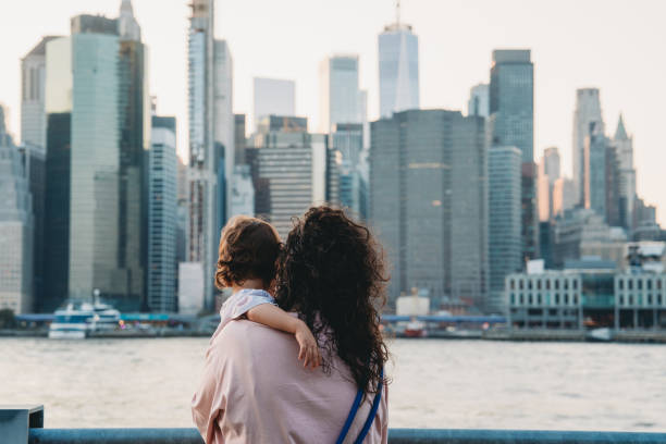 istock Mother holding baby while looking at manhattan skyline 2177423309