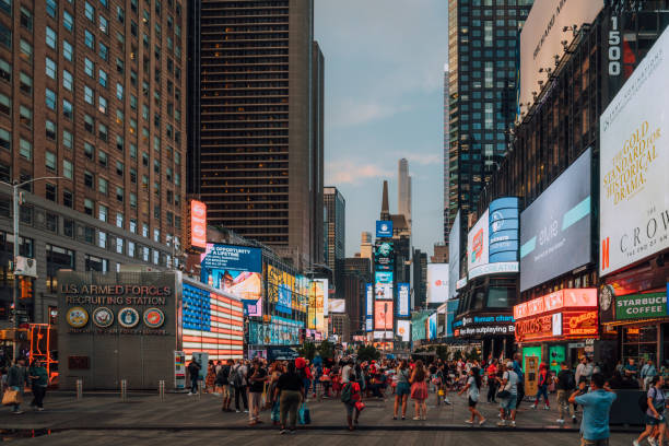 istock Tourists walking in times square with billboards at dusk 2177423403