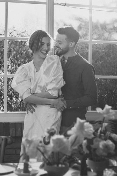 istock Happy couple embracing by window in black and white 2177423493