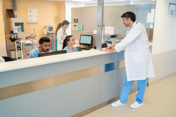 istock Doctor interacting with administrative worker at front desk 2177423572