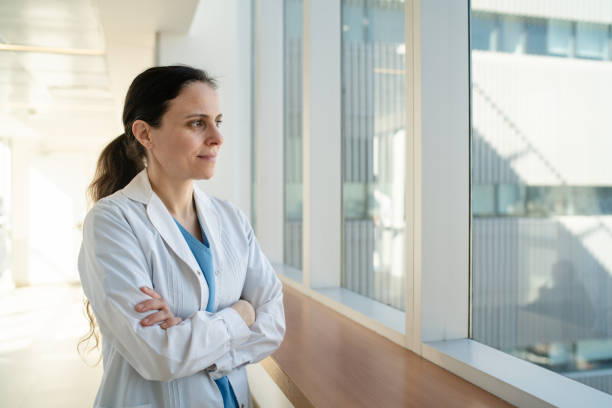 istock Doctor standing in hospital corridor by window 2177423631