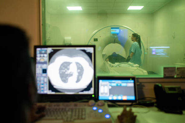 istock Senior patient on MRI scan machine viewed through control room 2177425091