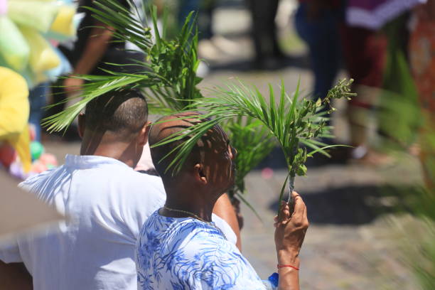 Close-up of hands holding a bouquet of palm leaves and flowers during a Palm Sunday celebration in Ecuador, a traditional Catholic observance marking the start of Holy Week