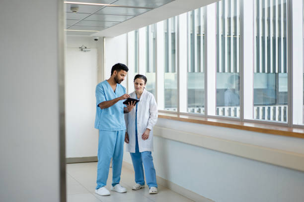 istock Two doctors standing in hospital corridor discussing work on digital tablet 2177427464