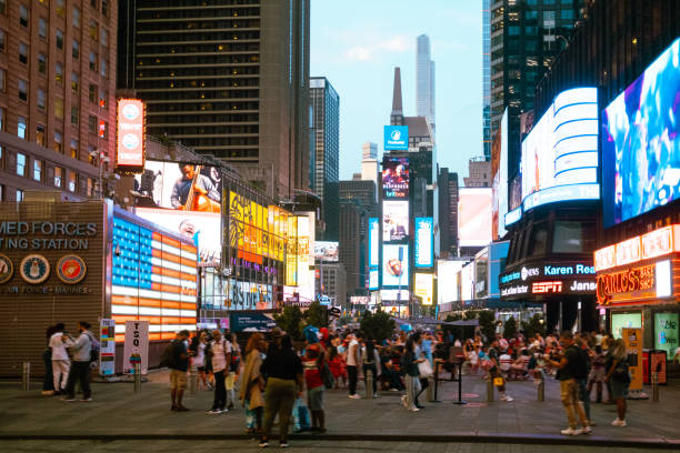 istock Tourists walking in times square with illuminated billboards at twilight 2177429248