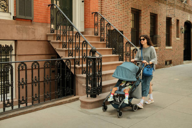 istock Mother pushing baby stroller walking on urban sidewalk 2177429336
