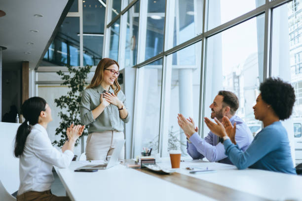 istock Businesswoman smiling with clapping team 2177431724