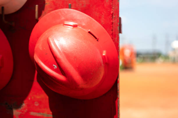 A safety helmet or hardhat, the safety PPE for construction worker is hanging in row. Industrial working equipment object, close-up.