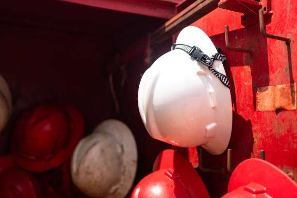 A safety helmet or hardhat, the safety PPE for construction worker is hanging in row. Industrial working equipment object, close-up.