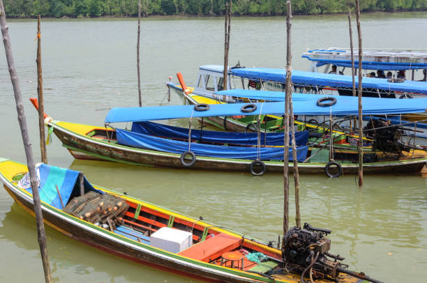 Colorful cambodian boats moored at the pier, decorated with flags, creating a vibrant scene