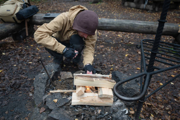 istock man starting a bonfire at picnic campfire in the forest 2177440285