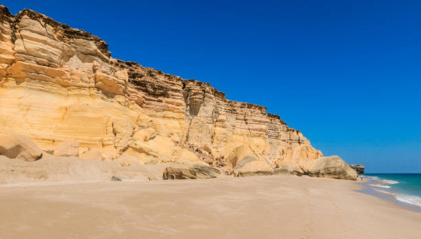 istock Explore the stunning turtle beach in Oman with its golden sands and majestic cliffs under a bright blue sky 2177440931