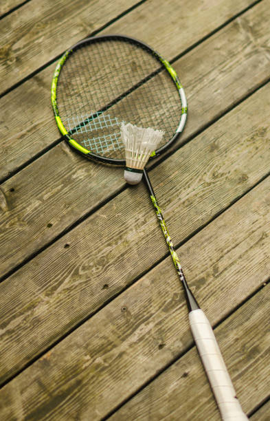 istock A shuttlecock with a badminton racket on the wooden floor. 2177441875