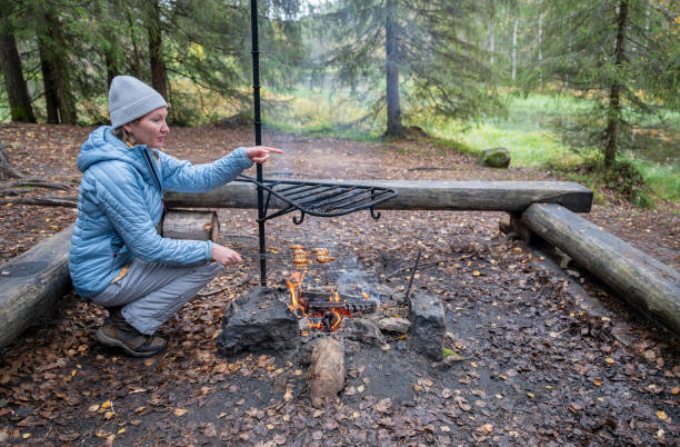 istock woman in the blue jacket cooking on a campfire in the forest 2177442482