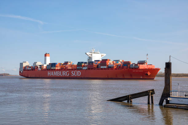 Reefer container ship CAP SAN MARCO, operated by shipping company  HAMBURG SÜD, passing Stadersand port on Elbe river heading to Hamburg ,