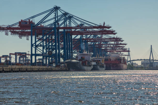 Hamburg, Germany – May 8, 2018: Container ships moored at Terminal Burchardkai  at the port of Hamburg. Köhlbrandbrücke bridge in background